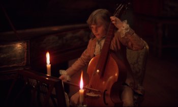 Movie still from “Barry Lyndon” (1975), directed by Stanley Kubrick – A young girl is playing the cello by candlelight; Medium shot, High angle