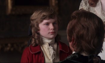 Movie still from “Barry Lyndon” (1975), directed by Stanley Kubrick – A young boy wearing a red jacket and a white shirt; Close Up shot, Over the shoulder angle