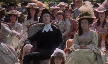 Movie still from “Barry Lyndon” (1975), directed by Stanley Kubrick – A group of people in period dress sitting in a chair; Medium shot, Low angle