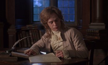 Movie still from “Barry Lyndon” (1975), directed by Stanley Kubrick – A man sitting at a table writing on a piece of paper; Medium shot, High angle