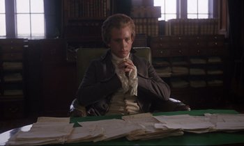 Movie still from “Barry Lyndon” (1975), directed by Stanley Kubrick – A man sitting at a desk in a room; Medium shot, High angle