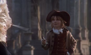 Movie still from “Barry Lyndon” (1975), directed by Stanley Kubrick – A child dressed as a musketeer holding a sword; Medium shot, Over the shoulder angle