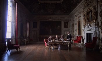Movie still from “Barry Lyndon” (1975), directed by Stanley Kubrick – A group of people sitting around a table in a room; Extreme Wide shot, High angle