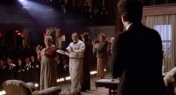 Movie still from “Barton Fink” (1991), directed by Joel Coen – A group of people standing in front of a stage; Wide shot, Over the shoulder angle