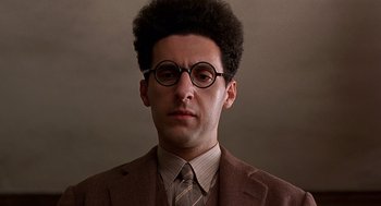 Movie still from “Barton Fink” (1991), directed by Joel Coen – A man in a suit and tie wearing glasses; Close Up shot, Low angle