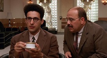 Movie still from “Barton Fink” (1991), directed by Joel Coen – Two men in suits and ties are sitting in a room; Close Up shot, Over the shoulder angle