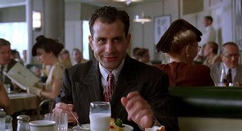 Movie still from “Barton Fink” (1991), directed by Joel Coen – A man sitting at a table with a plate of food; Close Up shot, Low angle