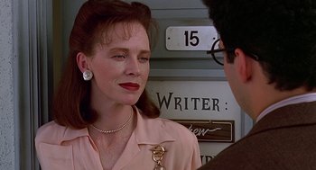 Movie still from “Barton Fink” (1991), directed by Joel Coen – A woman in a pink shirt is talking to a man in glasses; Close Up shot, Over the shoulder angle