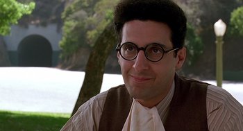 Movie still from “Barton Fink” (1991), directed by Joel Coen – A person wearing glasses and a vest; Close Up shot, Over the shoulder angle