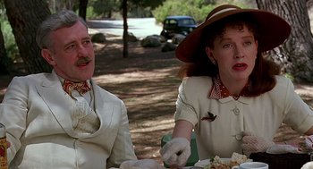 Movie still from “Barton Fink” (1991), directed by Joel Coen – A man and a woman sitting at a picnic table; Close Up shot, Low angle