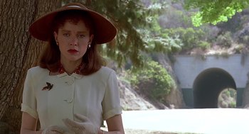 Movie still from “Barton Fink” (1991), directed by Joel Coen – A woman wearing a hat standing in front of a tree; Close Up shot, Low angle