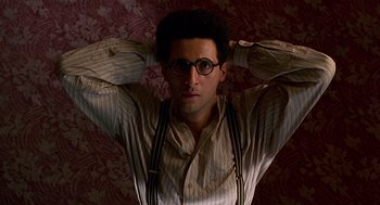 Movie still from “Barton Fink” (1991), directed by Joel Coen – A man with glasses is posing for a picture; Close Up shot, Low angle