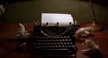 Movie still from “Barton Fink” (1991), directed by Joel Coen – An old fashioned type writer sitting on top of a wooden table; Extreme Close Up shot, High angle