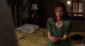 Movie still from “Barton Fink” (1991), directed by Joel Coen – A woman sitting on a bed in front of a lamp; Medium shot, High angle