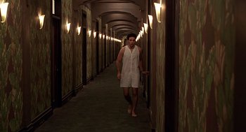 Movie still from “Barton Fink” (1991), directed by Joel Coen – A man walking down a hallway in a hotel room; Wide shot, High angle