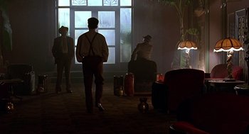 Movie still from “Barton Fink” (1991), directed by Joel Coen – A group of people standing in front of a large window; Wide shot, Low angle