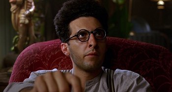 Movie still from “Barton Fink” (1991), directed by Joel Coen – A man wearing glasses sitting in a chair; Close Up shot, Low angle