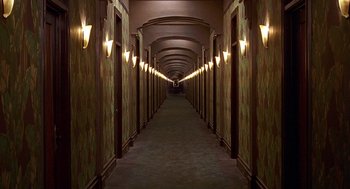 Movie still from “Barton Fink” (1991), directed by Joel Coen – A long hallway lined with lights in a building; Extreme Wide shot, High angle