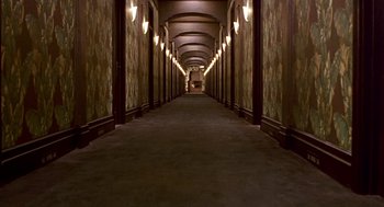 Movie still from “Barton Fink” (1991), directed by Joel Coen – A long hallway lined with lights in a building; Extreme Wide shot, High angle
