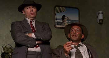 Movie still from “Barton Fink” (1991), directed by Joel Coen – A couple of men standing next to each other in a room; Medium shot, Low angle