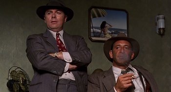 Movie still from “Barton Fink” (1991), directed by Joel Coen – A couple of men standing next to each other in a room; Medium shot, Low angle