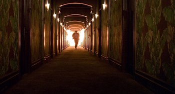 Movie still from “Barton Fink” (1991), directed by Joel Coen – A person is walking down a long hallway; Extreme Wide shot, Low angle