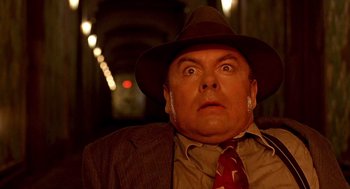 Movie still from “Barton Fink” (1991), directed by Joel Coen – A person wearing a suit and a hat; Close Up shot, Overhead angle