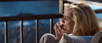 Movie still from “Basic Instinct” (1992), directed by Paul Verhoeven – A woman sitting down with a cigarette in her mouth; Close Up shot, Low angle