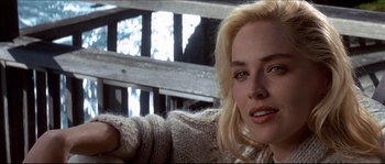 Movie still from “Basic Instinct” (1992), directed by Paul Verhoeven – A woman with blonde hair is sitting in a chair; Close Up shot, Over the shoulder angle