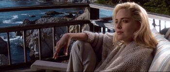 Movie still from “Basic Instinct” (1992), directed by Paul Verhoeven – A woman sitting on a chair on a deck; Medium shot, High angle