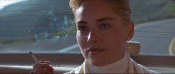 Movie still from “Basic Instinct” (1992), directed by Paul Verhoeven – A person with a cigarette in her mouth; Close Up shot, Over the shoulder angle