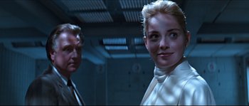 Movie still from “Basic Instinct” (1992), directed by Paul Verhoeven – A man and a woman standing next to each other; Close Up shot, Low angle