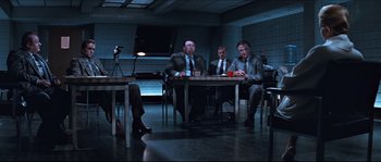 Movie still from “Basic Instinct” (1992), directed by Paul Verhoeven – A group of men sitting at a table in a room; Wide shot, High angle