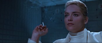 Movie still from “Basic Instinct” (1992), directed by Paul Verhoeven – A woman is holding a cigarette in her hand; Close Up shot, Low angle