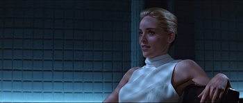 Movie still from “Basic Instinct” (1992), directed by Paul Verhoeven – A woman in a white dress standing next to a wall; Close Up shot, Low angle