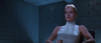 Movie still from “Basic Instinct” (1992), directed by Paul Verhoeven – A woman in a white top standing in a room; Medium shot, Low angle