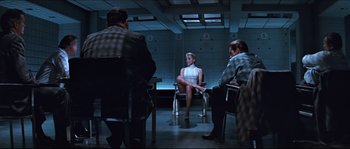 Movie still from “Basic Instinct” (1992), directed by Paul Verhoeven – A group of people sitting in a room; Wide shot, Over the shoulder angle