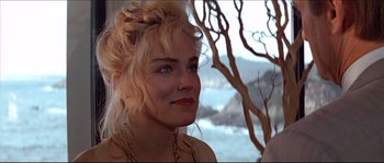 Movie still from “Basic Instinct” (1992), directed by Paul Verhoeven – A woman with blonde hair and blue eyes looking to her left; Close Up shot, Over the shoulder angle