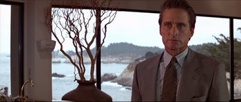 Movie still from “Basic Instinct” (1992), directed by Paul Verhoeven – A man standing in front of a window with a view of the ocean; Medium shot, Over the shoulder angle
