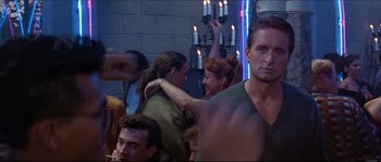 Movie still from “Basic Instinct” (1992), directed by Paul Verhoeven – A group of people in a room with candles on the wall; Medium shot, Over the shoulder angle