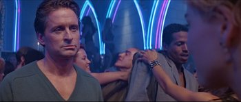 Movie still from “Basic Instinct” (1992), directed by Paul Verhoeven – A group of people in a room with lights in the background; Medium shot, Over the shoulder angle