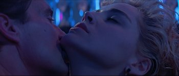 Movie still from “Basic Instinct” (1992), directed by Paul Verhoeven – A woman laying on top of another woman in a room; Close Up shot, Low angle