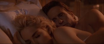 Movie still from “Basic Instinct” (1992), directed by Paul Verhoeven – A man and a woman laying in a bed together; Close Up shot, Over the shoulder angle