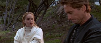 Movie still from “Basic Instinct” (1992), directed by Paul Verhoeven – A man and a woman standing next to each other in a field; Close Up shot, Over the shoulder angle