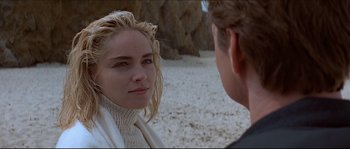 Movie still from “Basic Instinct” (1992), directed by Paul Verhoeven – A man and a woman standing on the beach; Close Up shot, Over the shoulder angle