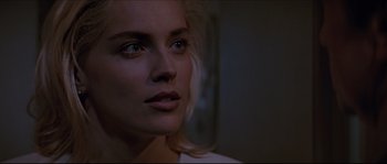 Movie still from “Basic Instinct” (1992), directed by Paul Verhoeven – A woman's face in a dark room; Close Up shot, Over the shoulder angle