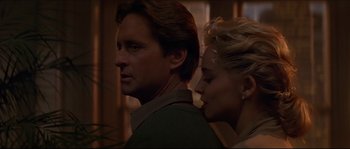 Movie still from “Basic Instinct” (1992), directed by Paul Verhoeven – A man and a woman standing next to each other; Close Up shot, Low angle