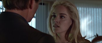 Movie still from “Basic Instinct” (1992), directed by Paul Verhoeven – A man and a woman looking at one another in a room; Close Up shot, Over the shoulder angle