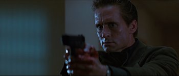 Movie still from “Basic Instinct” (1992), directed by Paul Verhoeven – A person holding a gun in a dark room; Close Up shot, Low angle