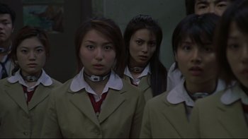 Movie still from “Battle Royale” (2000), directed by Kinji Fukasaku – A group of young women standing next to each other; Close Up shot, Low angle